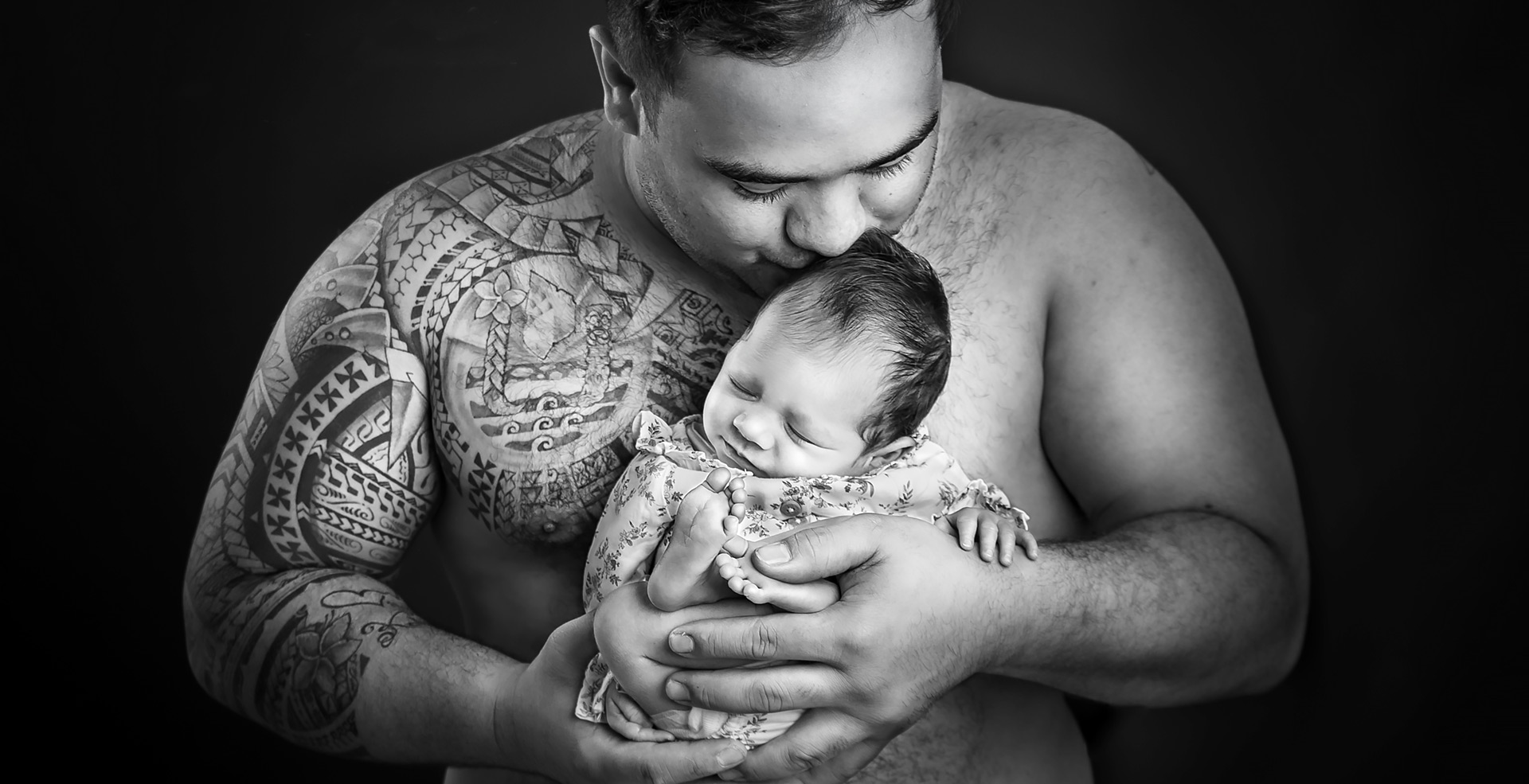 photo de bébé dans les bras de son papa maori au studio
