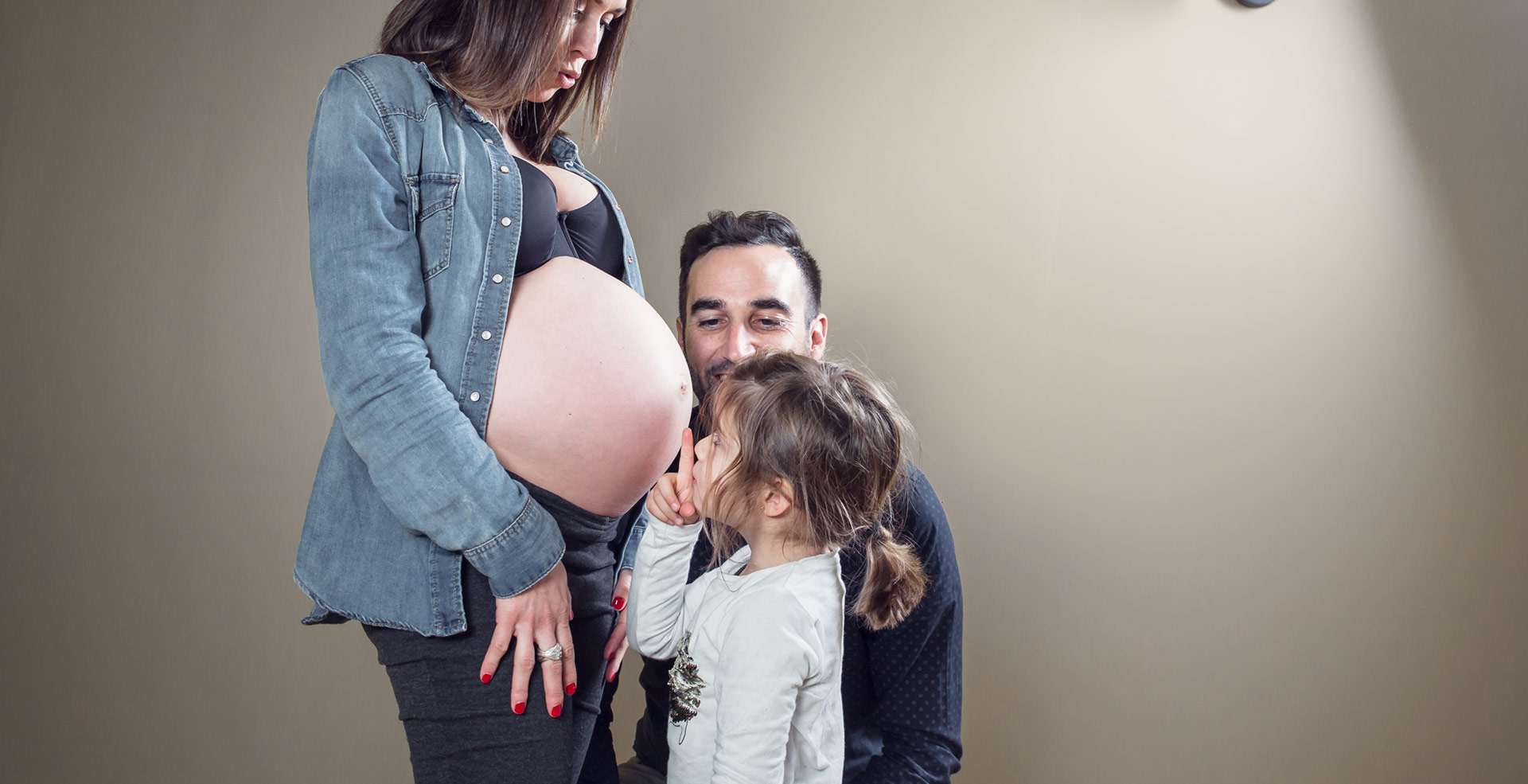 photo de grossesse en famille avec bisou ventre rond